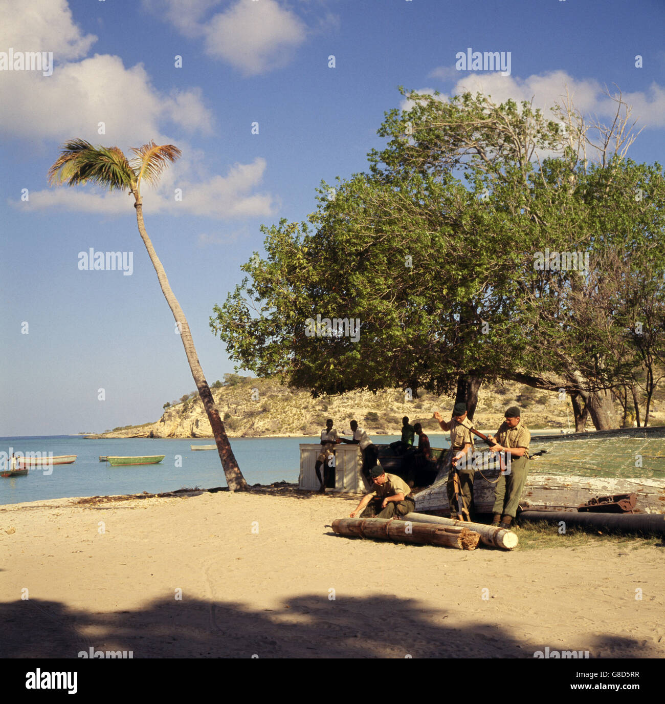 Royal Marines reinigen ihre Waffen im Schatten eines Baumes am sonnenbeschienenen Meer auf Anguilla. Britische Truppen sowie britischer Polizist wurden nach politischen Unruhen auf die Insel geschickt. Die Insel hat sich für die Unabhängigkeit von Großbritannien eingesetzt. Stockfoto