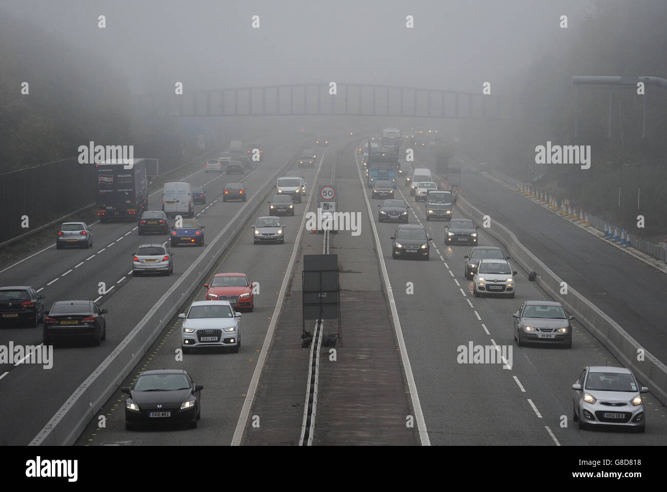 Der Verkehr macht seinen Weg durch dichten Nebel zwischen den Kreuzungen 4 und 4a der M3 Autobahn in der Nähe von Frimley in Surrey. Stockfoto