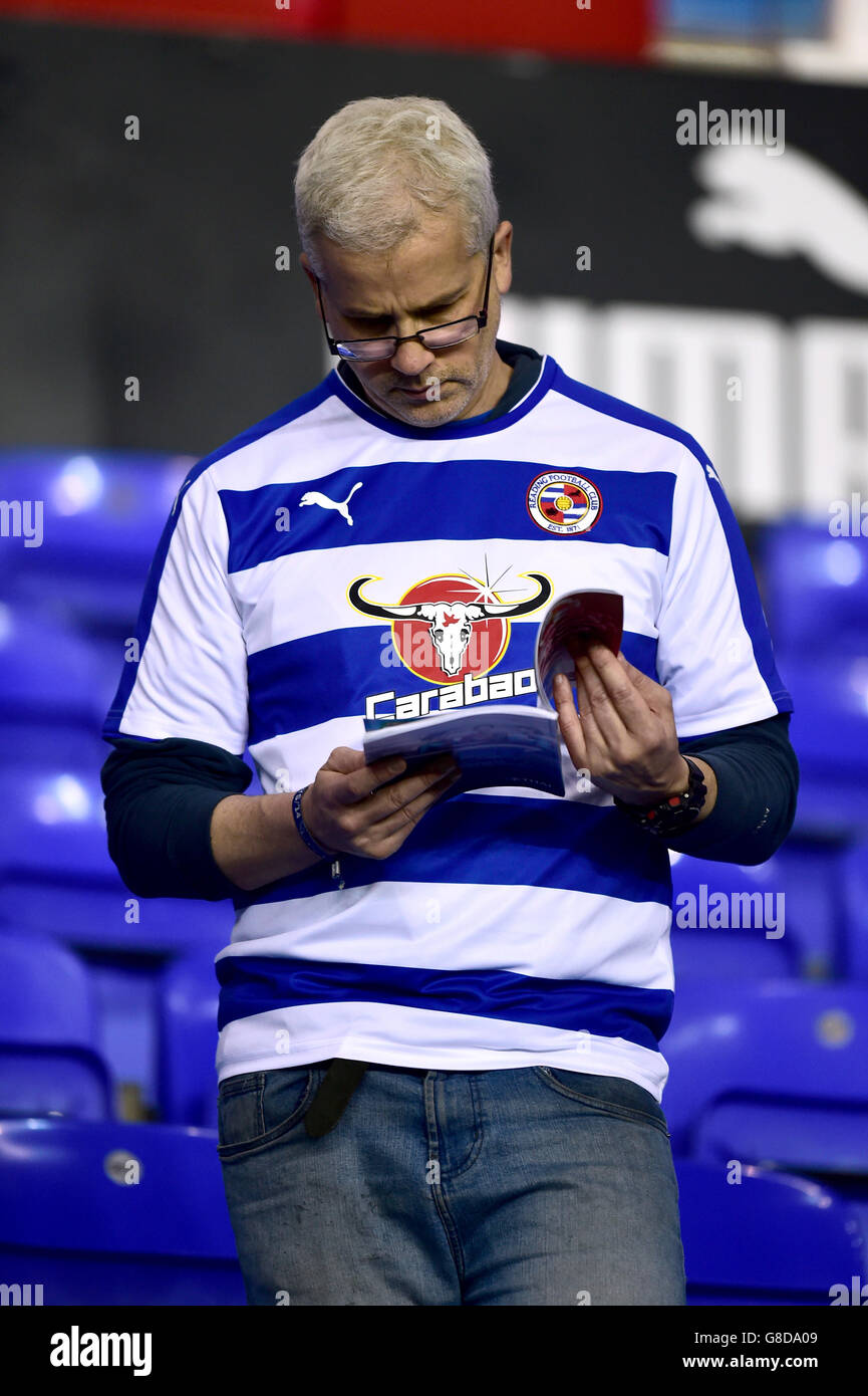 Fußball - Sky Bet Championship - Reading / Huddersfield Town - Madejski Stadium. Ein Reading-Fan liest das Spieltagsprogramm in den Ständen vor dem Spiel Stockfoto