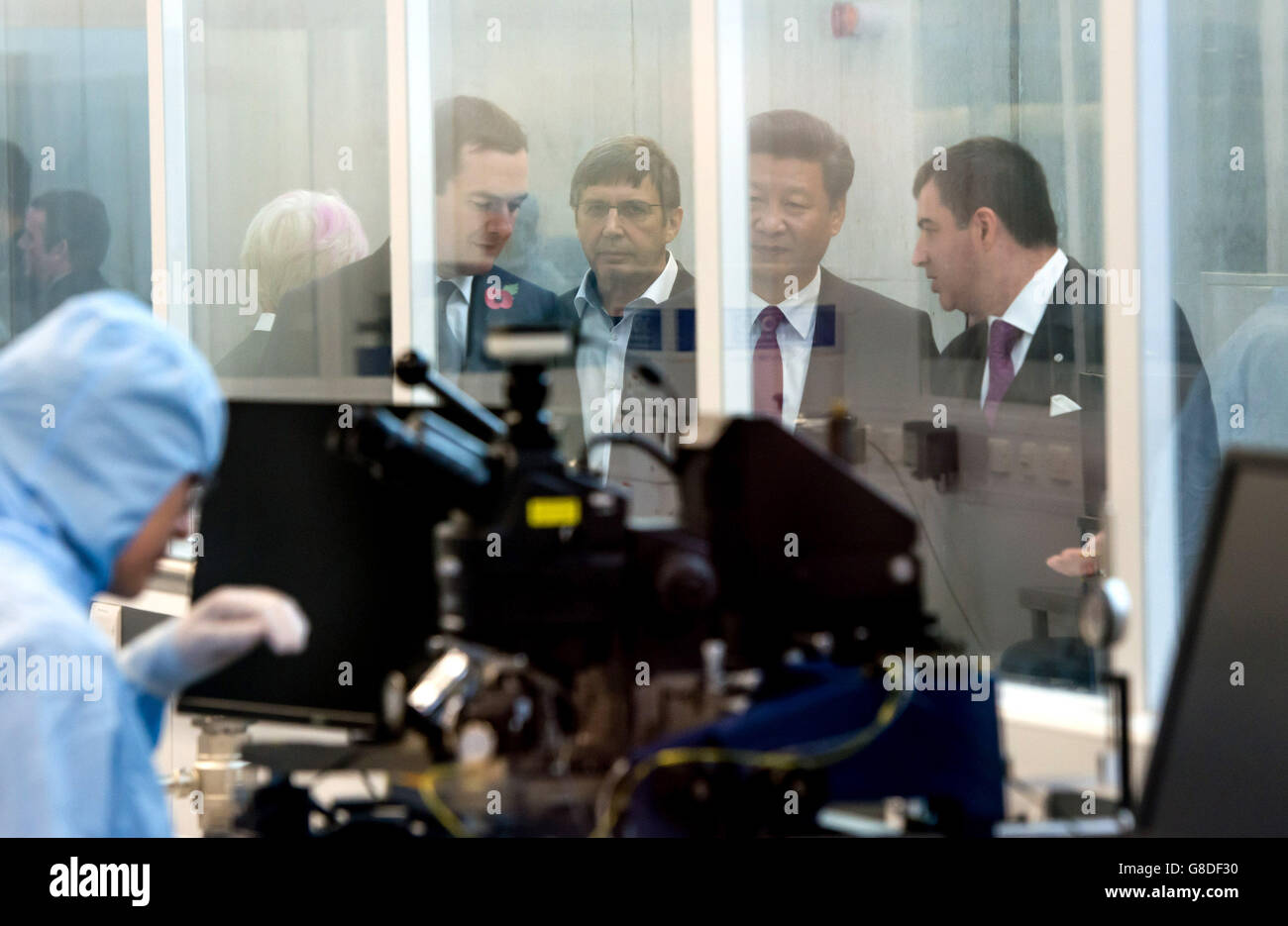 Bundeskanzler George Osborne (links) und der Präsident der Volksrepublik China, Herr Xi Jinping (Mitte), werden durch das Nationale Graphene Institut in Manchester geführt. Stockfoto