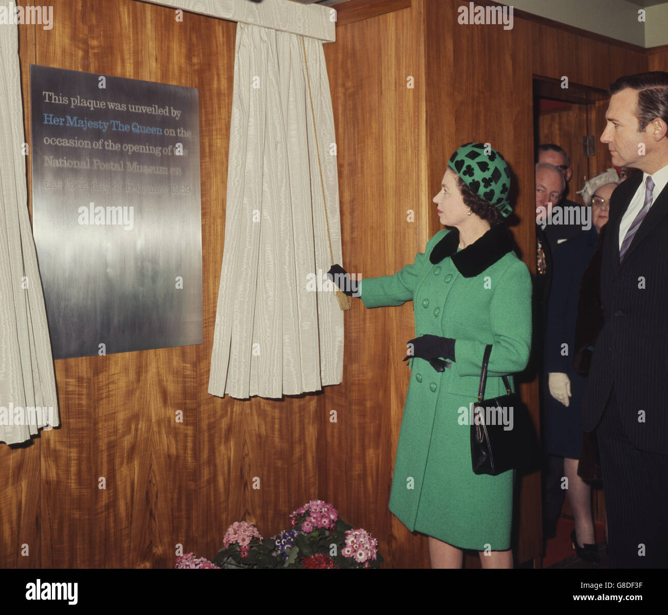 Die Königin enthüllt eine Gedenktafel, als sie das National Postal Museum im Londoner Hauptpostamt, King Edward Building, eröffnet. Auf der rechten Seite ist John Stonehouse, der Postmeister General. Stockfoto