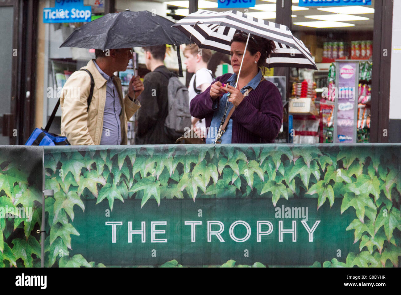 Wimbledon London, UK. 28. Juni 2016.  Zuschauer mit Sonnenschirmen Zuflucht vor dem Regen in Wimbledon am Tag2 des 2016 Wimbledon Tennis-Meisterschaften: Amer Ghazzal/Alamy Live-Nachrichten Stockfoto