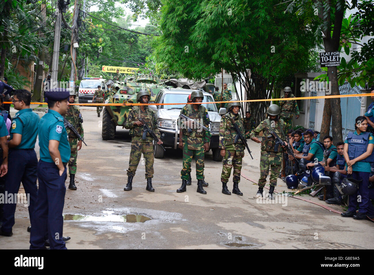 Bangladeshi Soldaten und Polizisten Fuß entlang einer Straße, die führt zu einem gehobenen Restaurant in Dhaka am 2. Juli 2016, nach einem blutigen Belagerung es durch bewaffnete Angreifer, die am 1. Juli begonnen. Schwer bewaffnete Kämpfer ermordeten 20 Geiseln in Bangladesch, viele ihrer Opfer zu Tode, hacking, bevor sechs der Angreifer am Ende einer Belagerung niedergeschossen wurden 2 Juli in einem Restaurant mit Ausländern verpackt. Wie die Gruppe islamischer Staat (IS) Verantwortung für das Blutbad zu Beginn des Urlaubs Eid behauptet, sagte Premierminister Sheikh Hasina, dass sie fest entschlossen war, Militanz in der überwiegend muslimischen Na zu beseitigen Stockfoto