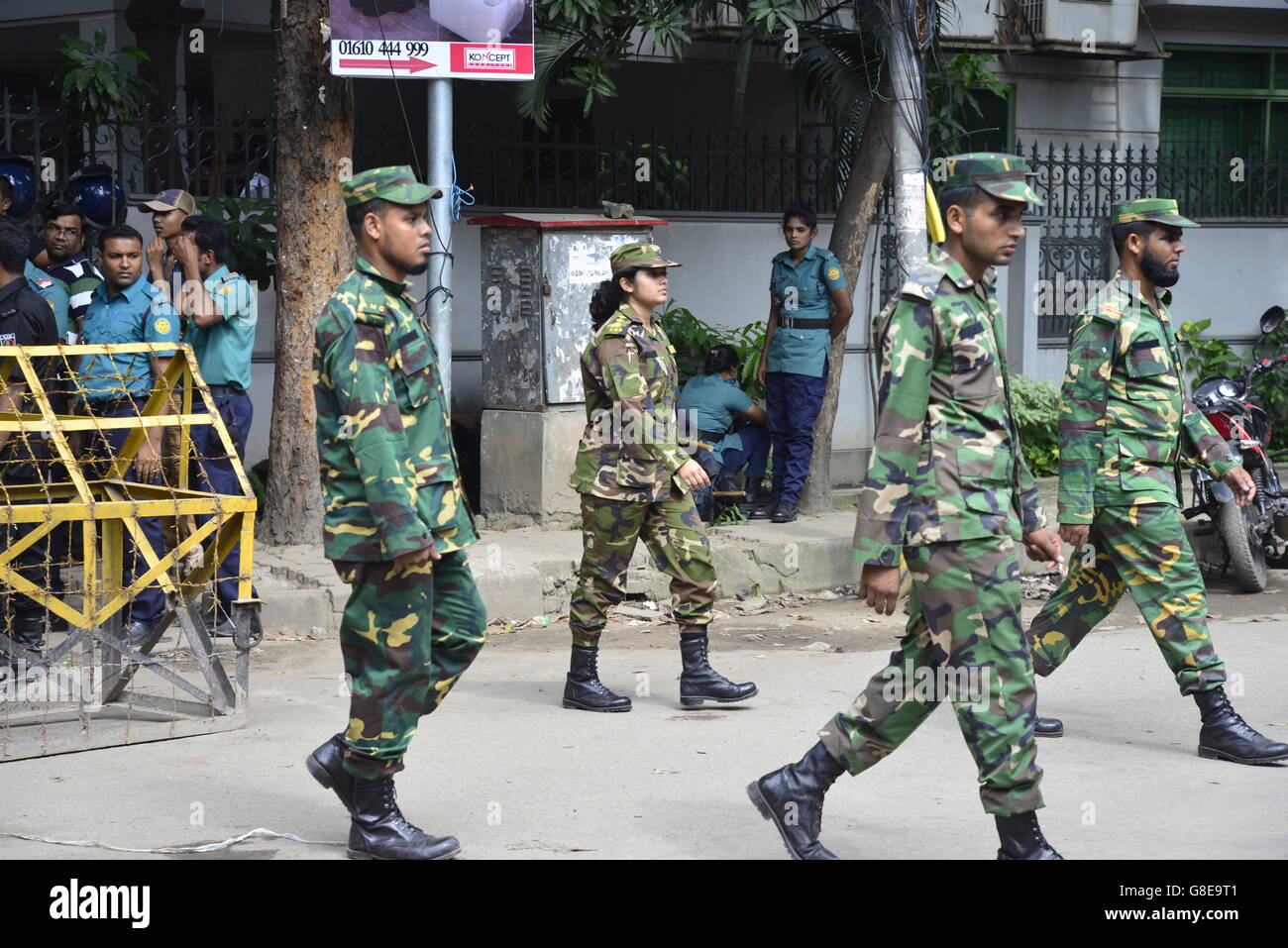 Bangladeshi Soldaten und Polizisten Fuß entlang einer Straße, die führt zu einem gehobenen Restaurant in Dhaka am 2. Juli 2016, nach einem blutigen Belagerung es durch bewaffnete Angreifer, die am 1. Juli begonnen. Schwer bewaffnete Kämpfer ermordeten 20 Geiseln in Bangladesch, viele ihrer Opfer zu Tode, hacking, bevor sechs der Angreifer am Ende einer Belagerung niedergeschossen wurden 2 Juli in einem Restaurant mit Ausländern verpackt. Wie die Gruppe islamischer Staat (IS) Verantwortung für das Blutbad zu Beginn des Urlaubs Eid behauptet, sagte Premierminister Sheikh Hasina, dass sie fest entschlossen war, Militanz in der überwiegend muslimischen Na zu beseitigen Stockfoto