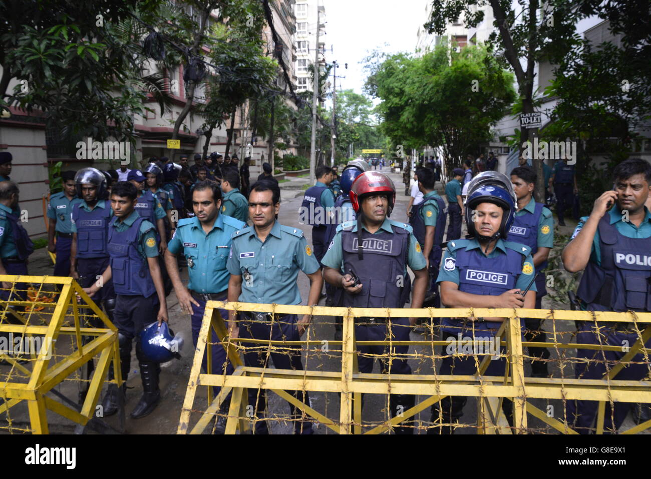 Bangladeshi Soldaten und Polizisten Fuß entlang einer Straße, die führt zu einem gehobenen Restaurant in Dhaka am 2. Juli 2016, nach einem blutigen Belagerung es durch bewaffnete Angreifer, die am 1. Juli begonnen. Schwer bewaffnete Kämpfer ermordeten 20 Geiseln in Bangladesch, viele ihrer Opfer zu Tode, hacking, bevor sechs der Angreifer am Ende einer Belagerung niedergeschossen wurden 2 Juli in einem Restaurant mit Ausländern verpackt. Wie die Gruppe islamischer Staat (IS) Verantwortung für das Blutbad zu Beginn des Urlaubs Eid behauptet, sagte Premierminister Sheikh Hasina, dass sie fest entschlossen war, Militanz in der überwiegend muslimischen Na zu beseitigen Stockfoto