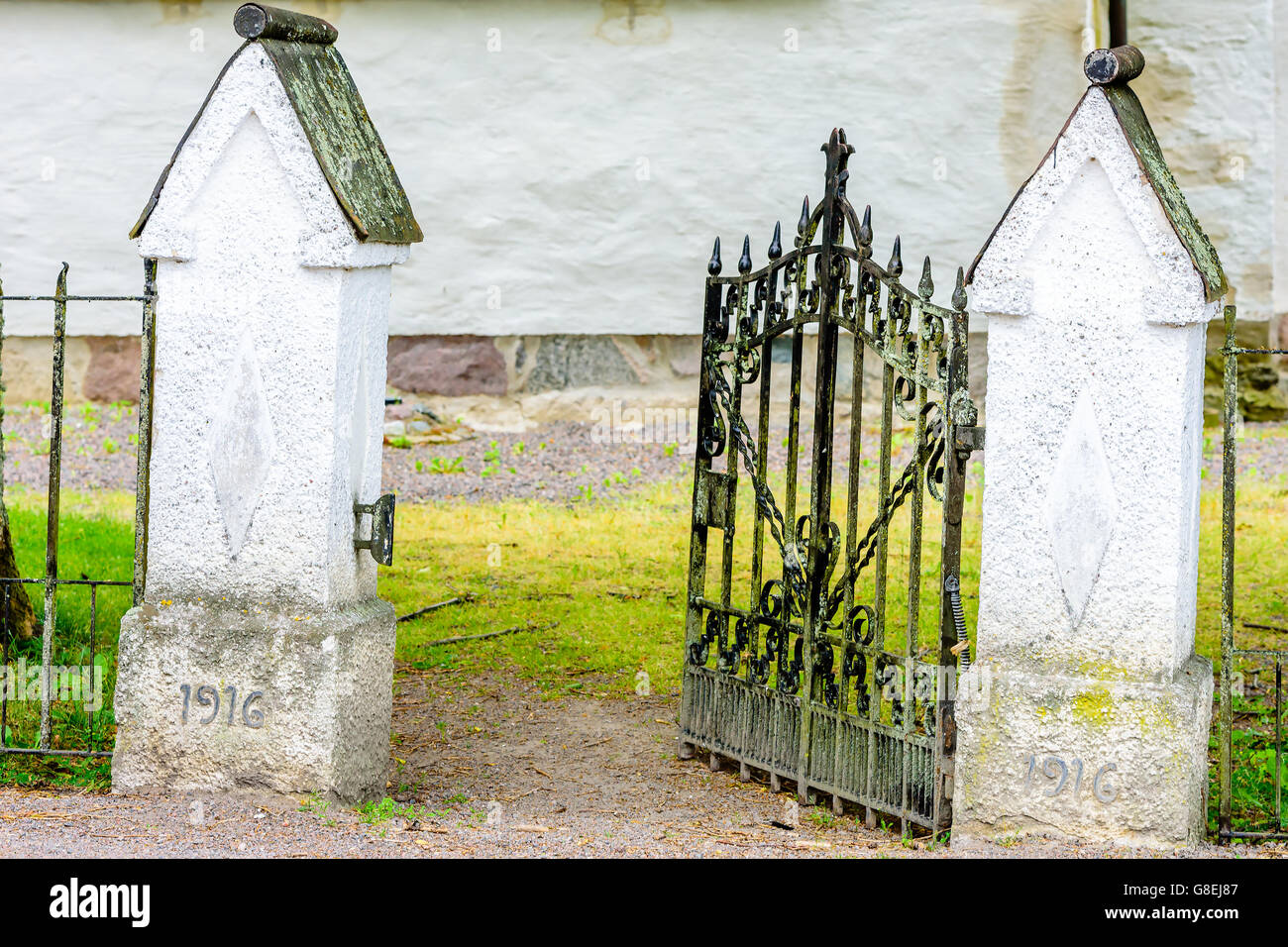 Offenen Friedhof Tor mit Teil der Kirche hinter. Tor ist etwas geneigt. Das Jahr 1916 ist sichtbar auf den Torpfosten. Stockfoto