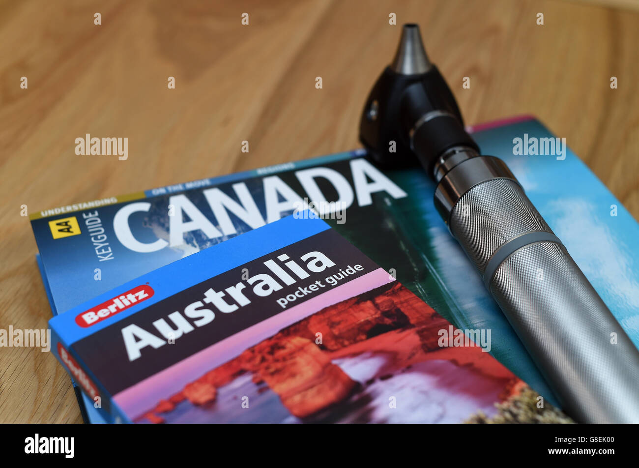 Ein Arztoskop liegt auf Reiseführern nach Australien und Kanada Stockfoto