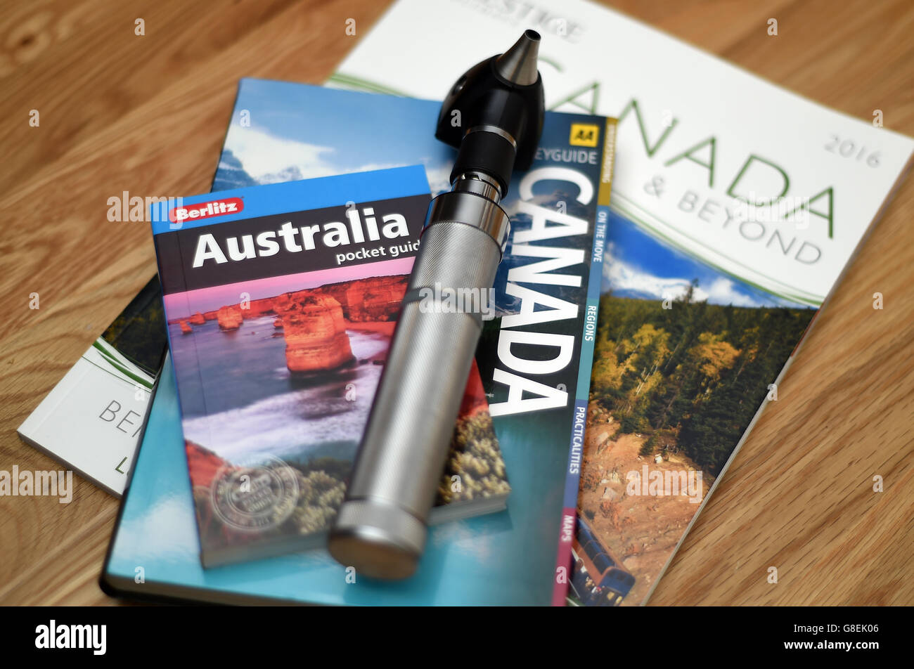 Ein Arztoskop liegt auf Reiseführern nach Australien und Kanada Stockfoto