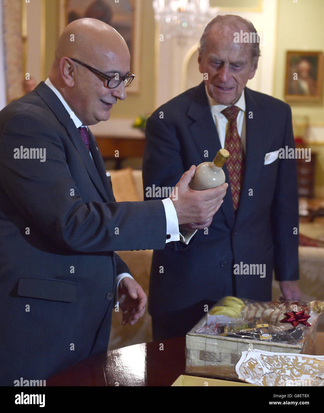 Der Herzog von Edinburgh hält eine Flasche irischer Sahne-Likör, während er Geschenke mit Edgar Preca, dem Ehemann der maltesischen Präsidentin Marie Louise Coleiro, während eines Besuchs im San Anton Palace in Attard austauscht. Stockfoto