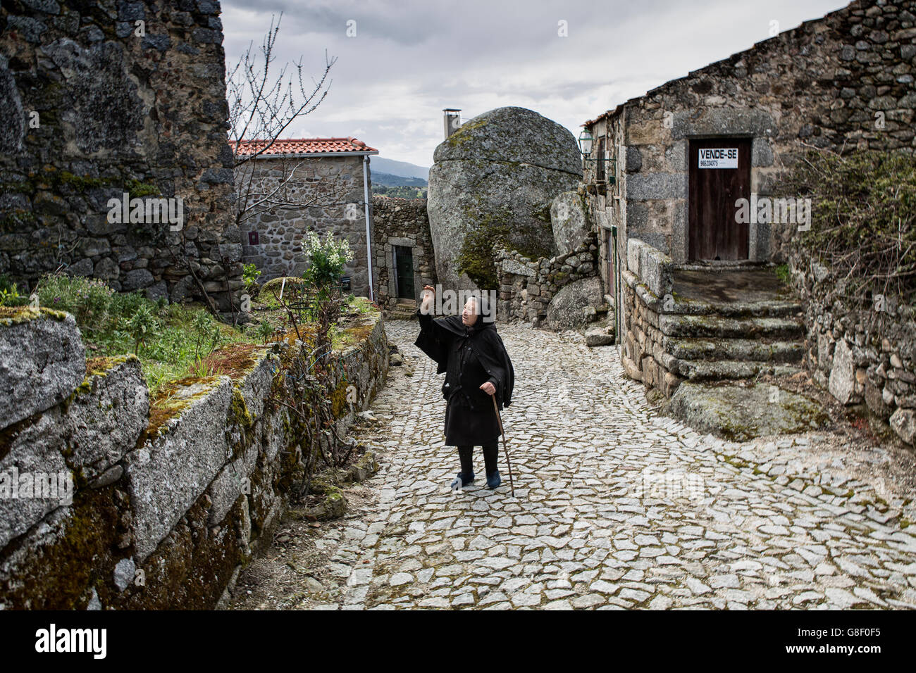 Eine ältere Witwe in der alten mittelalterlichen Straßen von Linhares, Serra da Estrela, Portugal Stockfoto