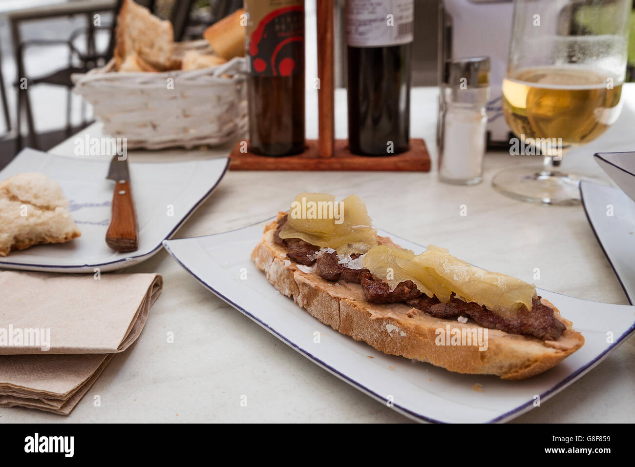 Scheibe Brot mit Rinderfilet, Gänseleber und karamellisiertem Apfel. Stockfoto