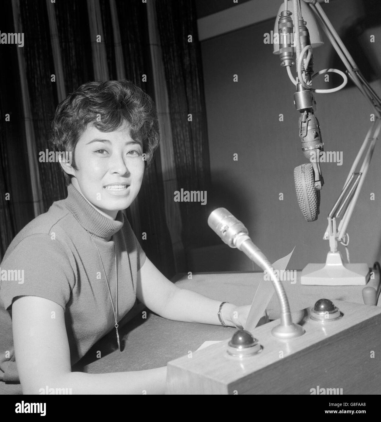 An einem Mikrofon im Broadcasting House, London, ist Lucia Liu zu sehen, eine von zwei Sprechern, die den britischen Radiohörern Unterricht auf Chinesisch geben sollen. Zum ersten Mal in diesem Herbst nimmt die BBC Mandarin in ihre Liste der Sprachkurse im Radio auf. Stockfoto
