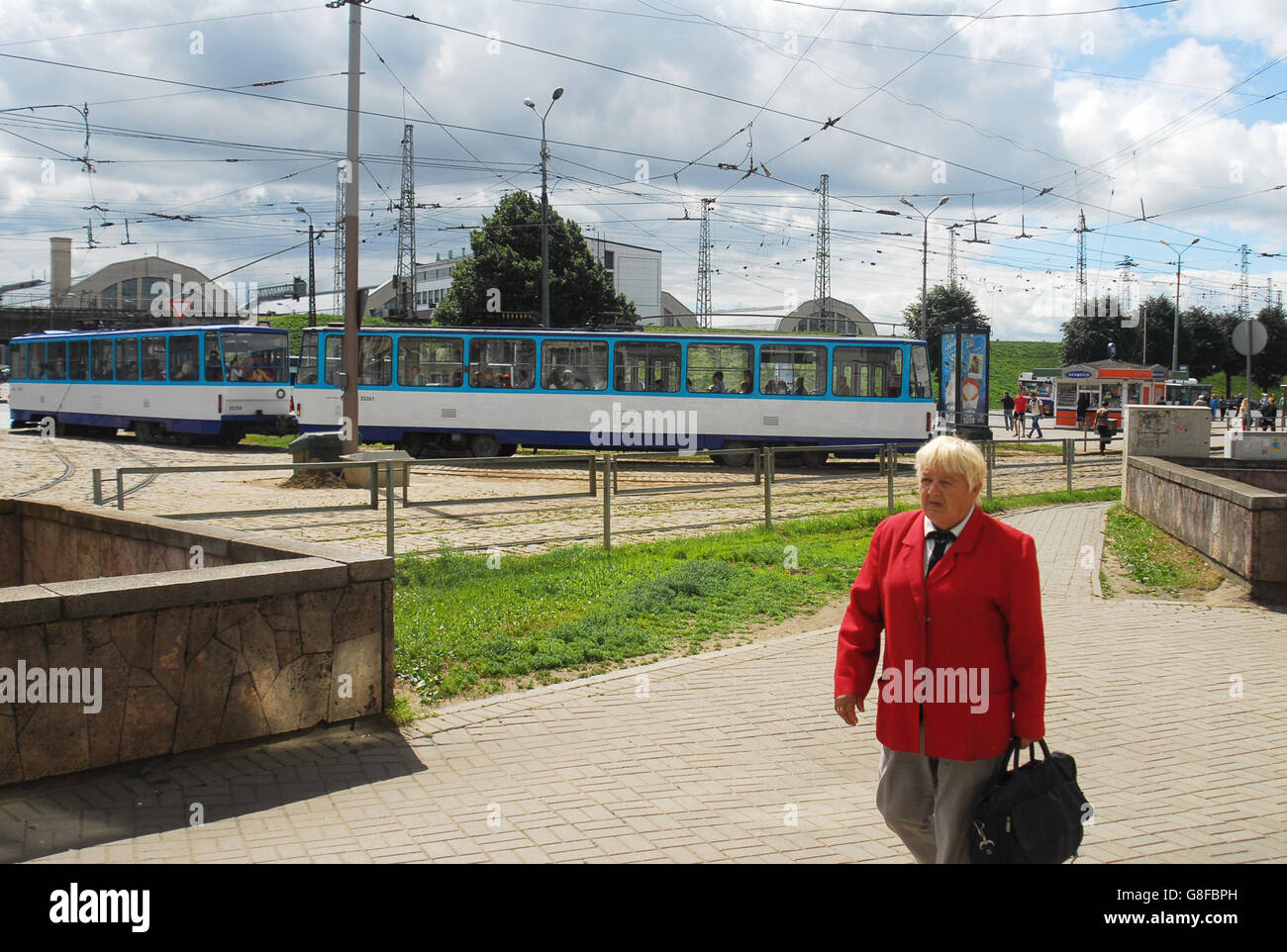 Frau in rotem Kleid geht durch das Stadtzentrum von Riga, der größten Stadt und Hauptstadt Lettlands, der europäischen Kulturhauptstadt im Jahr 2014. Stockfoto