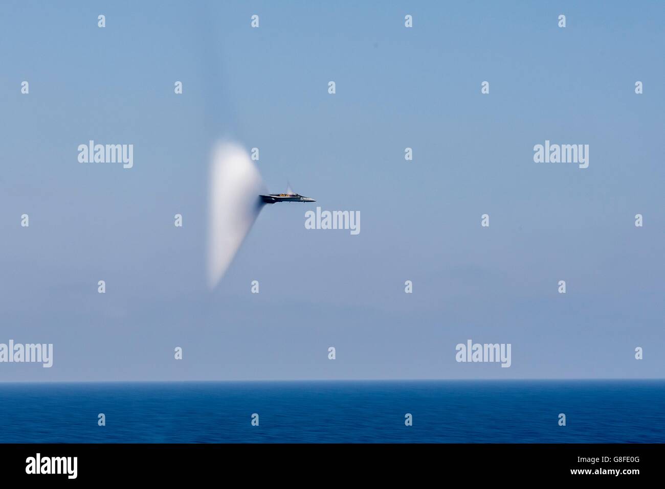 Ein Kampfflugzeug der US Navy F/A - 18C Hornet bricht die Schallmauer während eines Überschall Vorbeiflug der USS Harry S. Truman 26. Juni 2016 im Mittelmeer. Stockfoto