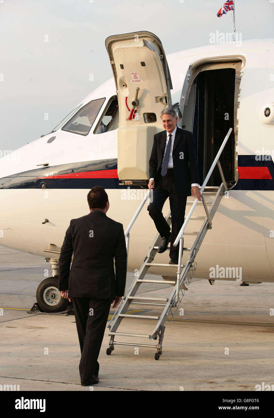 Außenminister Philip Hammond (oben) verlässt das Flugzeug, um von Nichola Cannon, HMA, bei der Ankunft am Flughafen Tirana, Albanien, begrüßt zu werden. Stockfoto