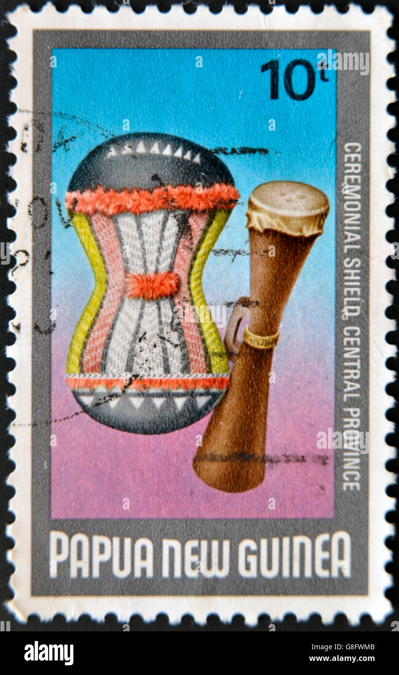 PAPUA NEUGUINEA - CIRCA 1984: Eine Briefmarke gedruckt in Papua Neuguinea zeigt zu Musikinstrumenten, zeremoniellen Schild für zentrale p Stockfoto
