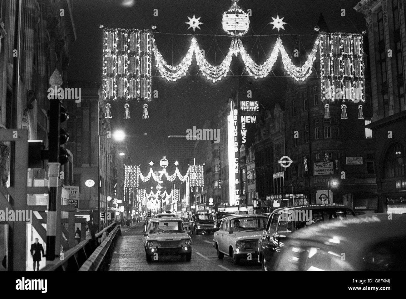 Goldene Wandteppiche, die durch Lichtgunst über dem Verkehr in der Oxford Street, London, verbunden sind, nachdem die Weihnachtsbeleuchtung der Einkaufsstraße von Lord Geddes, dem Vorsitzenden der British Travel Association, offiziell eingeschaltet worden war. Stockfoto
