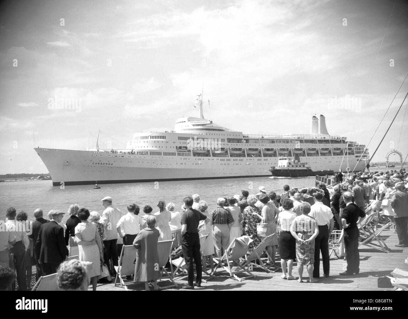 Wochenend-Urlauber, die sich in Liegestühlen sonnen hatten, geben dem Liner Canberra einen Standing-off, als sie Southampton nach Australien verlässt. Sie war das erste Schiff, das seit dem Ende des Matrosenstreiks mit Passagieren aus dem Hafen segelte. Stockfoto