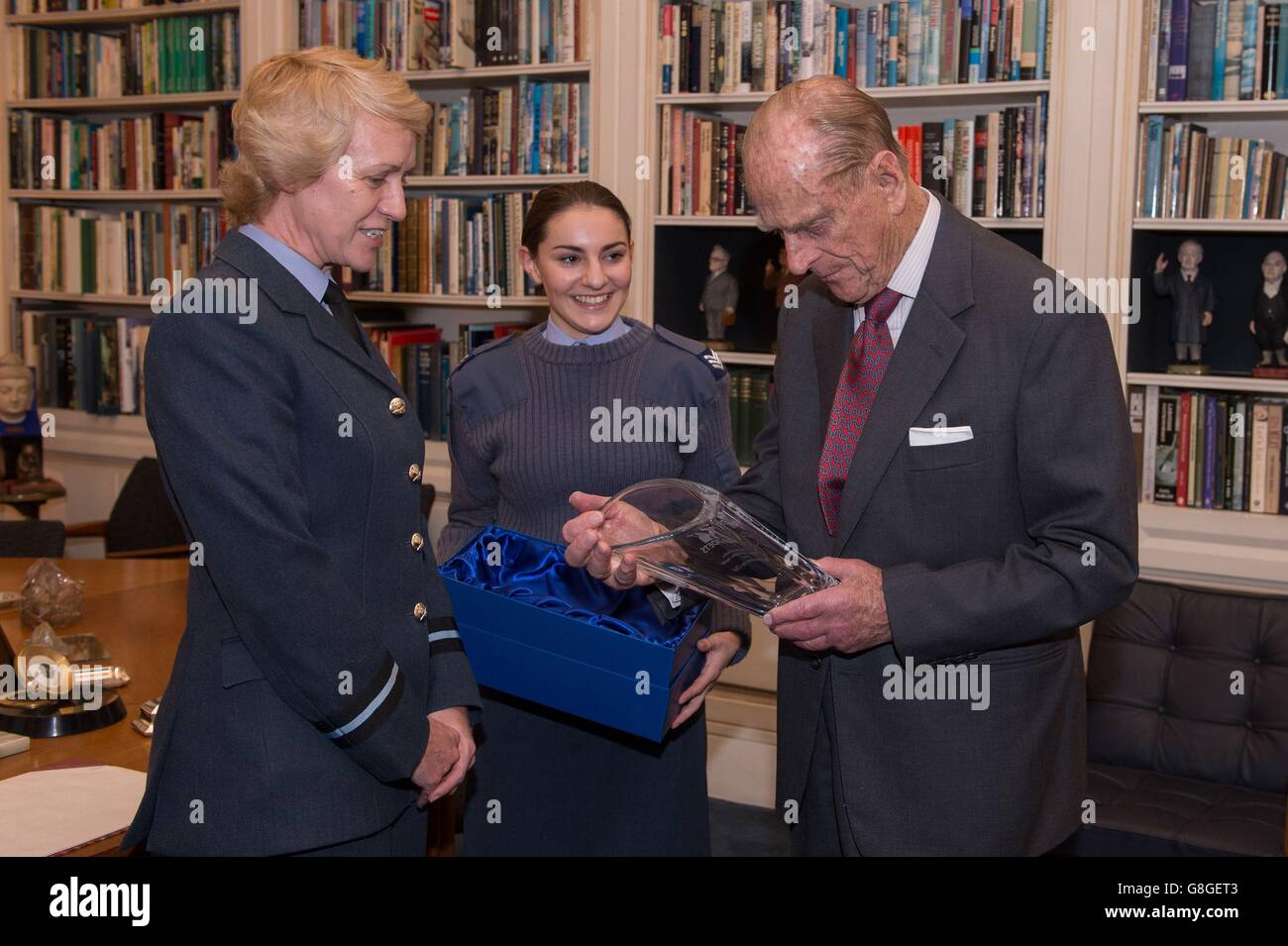 Cadet Sergeant Bronwyn Jacobs (Mitte) steht mit dem Duke of Edinburgh, als er mit einem Geschenk einer Vase von Air Commodore Dawn McCafferty Kommandant der Air Cadet Organisation (links) am Buckingham Palace in London präsentiert wird, Als er sich vom Posten von Air Commodore in Chief und anlässlich der Herzogin von Cambridge wurde Ehrenbefehlshaber der Air Cadets. Stockfoto