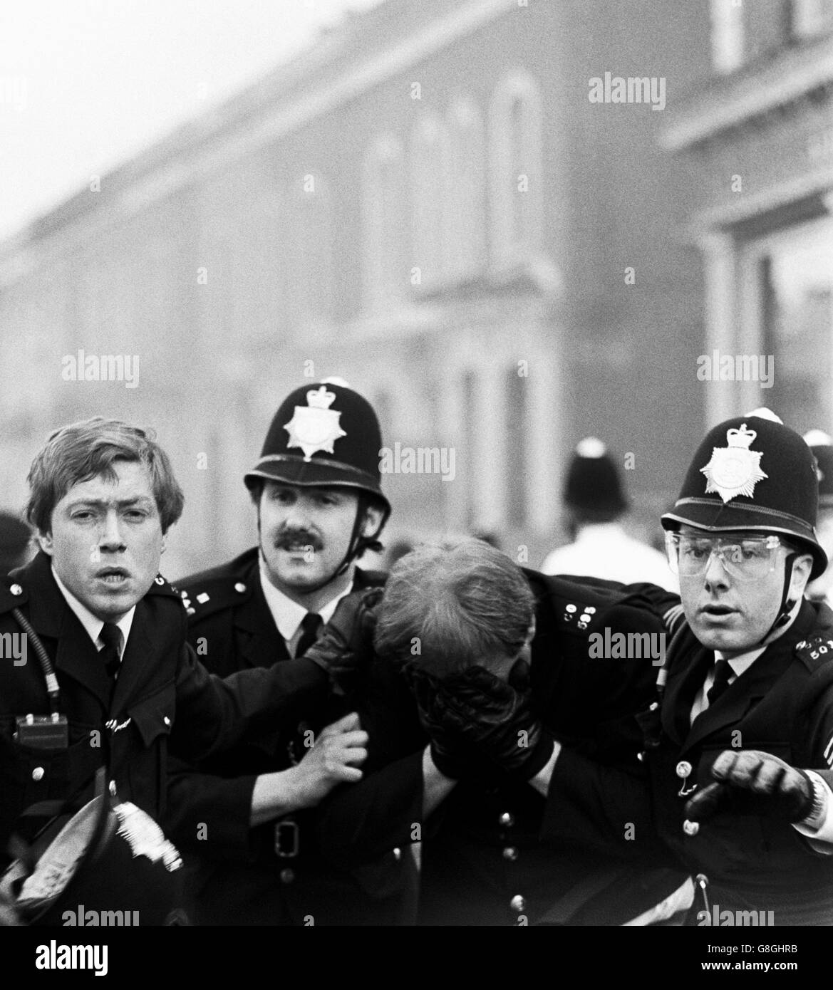 Kollegen helfen einem Polizisten, der von einer Benzinbombe in Brixton getroffen wurde, während erneuter Kämpfe zwischen Polizei und schwarzen Jugendlichen. Stockfoto