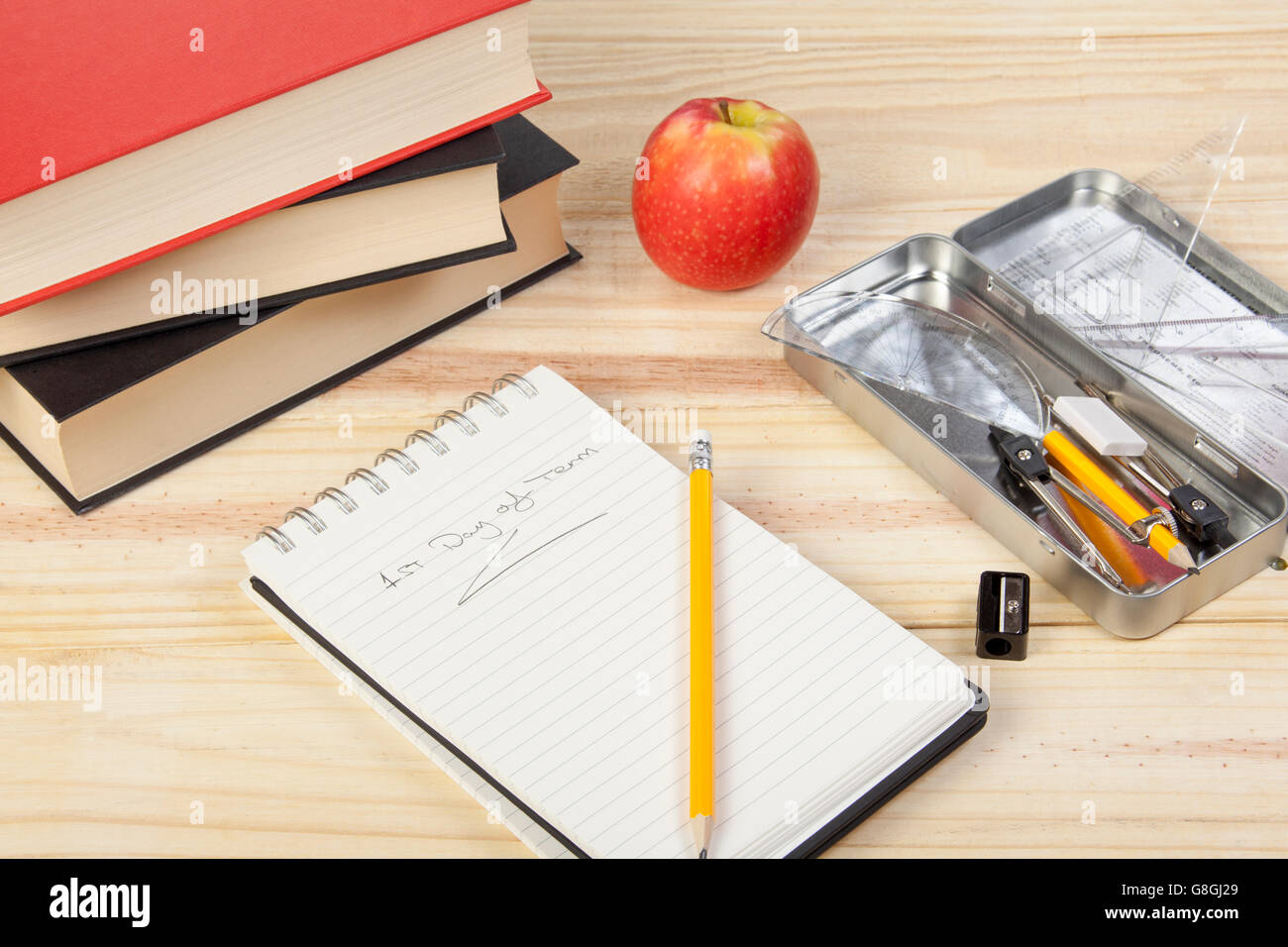 Schule-Desktop mit einer offen Notepad zeigt 1. Schultag sowie einige Lehrbücher, Apfel und Bleistift Anspitzer Stockfoto