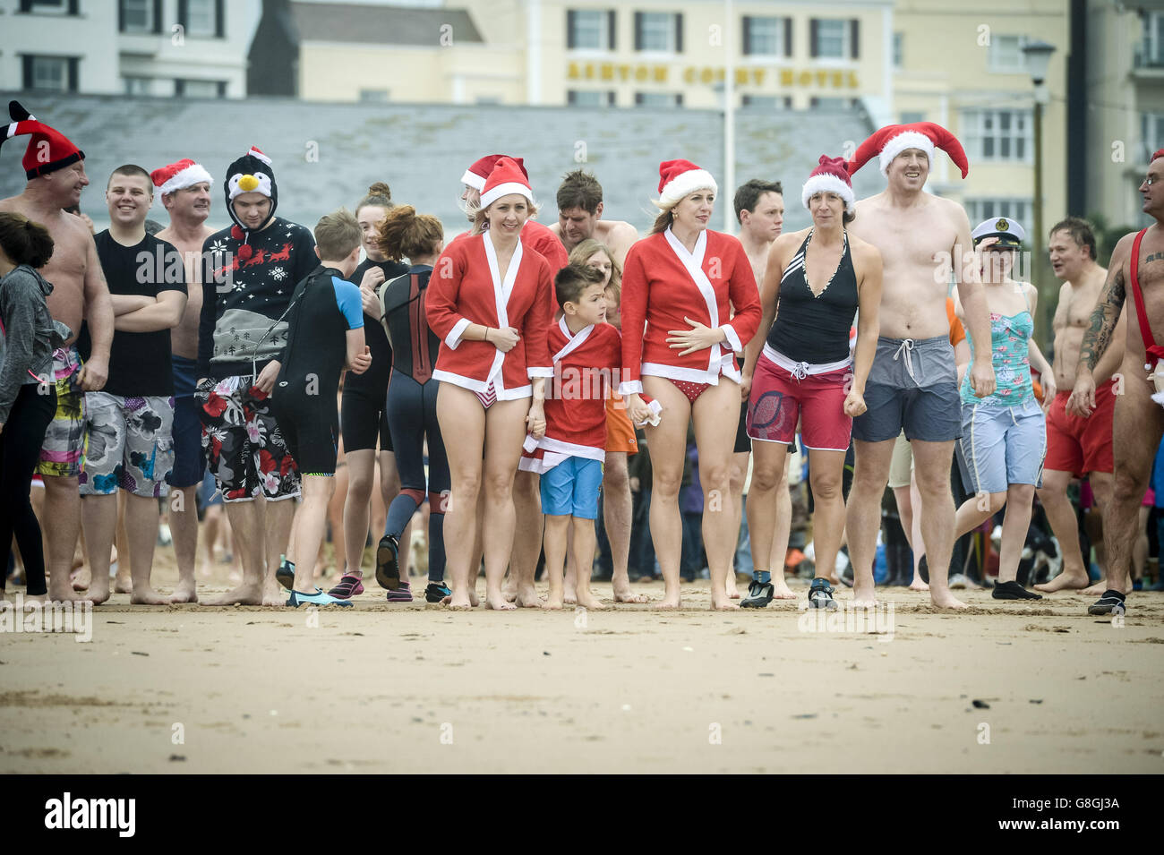 Die Leute säumen den Strand, um am jährlichen Exmouth Christmas Day Schwimmen am Exmouth Beach, Devon, teilzunehmen. Stockfoto