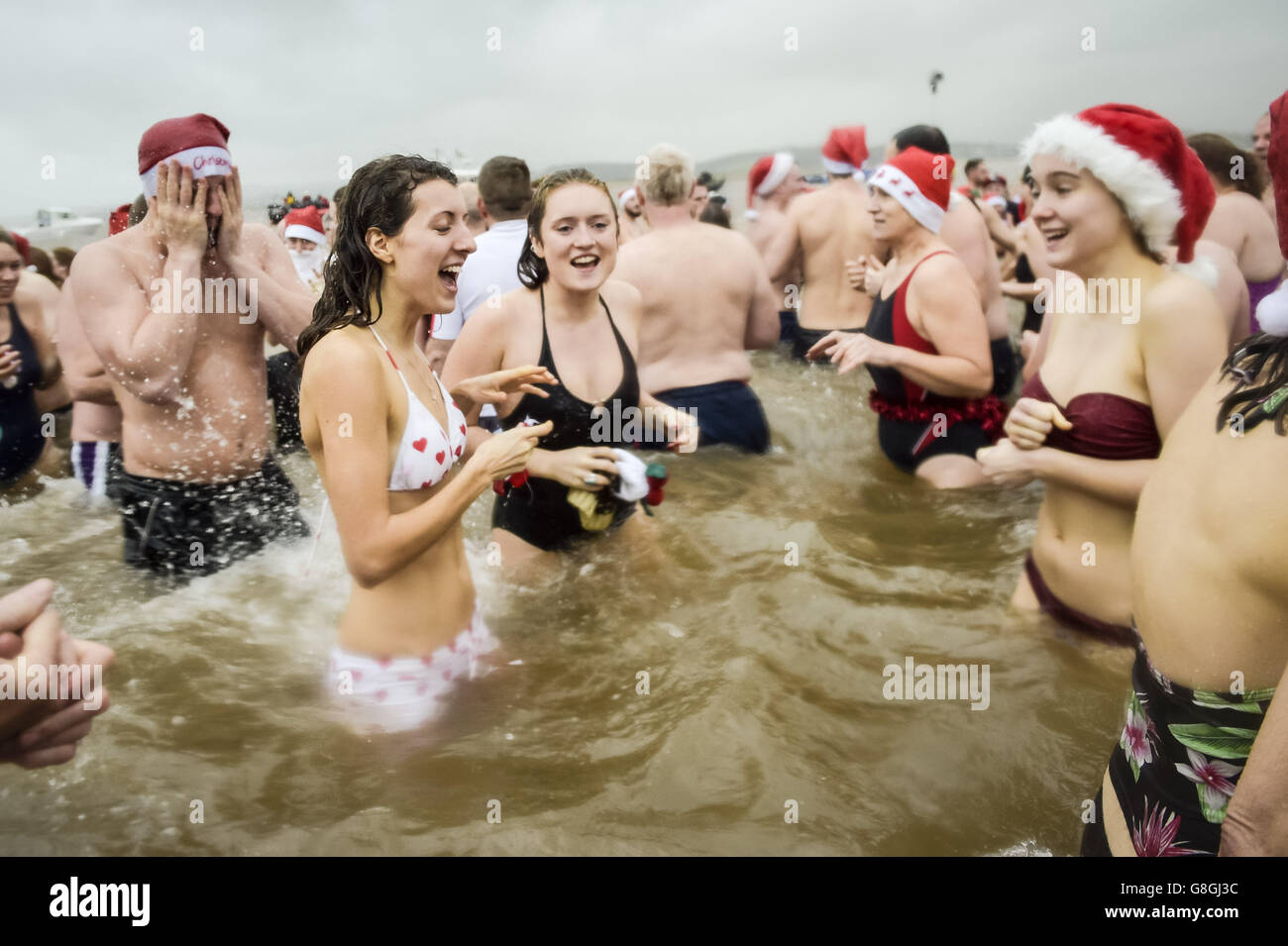 Am Exmouth Beach, Devon, nehmen die Menschen am jährlichen Exmouth Christmas Day Schwimmen Teil. Stockfoto