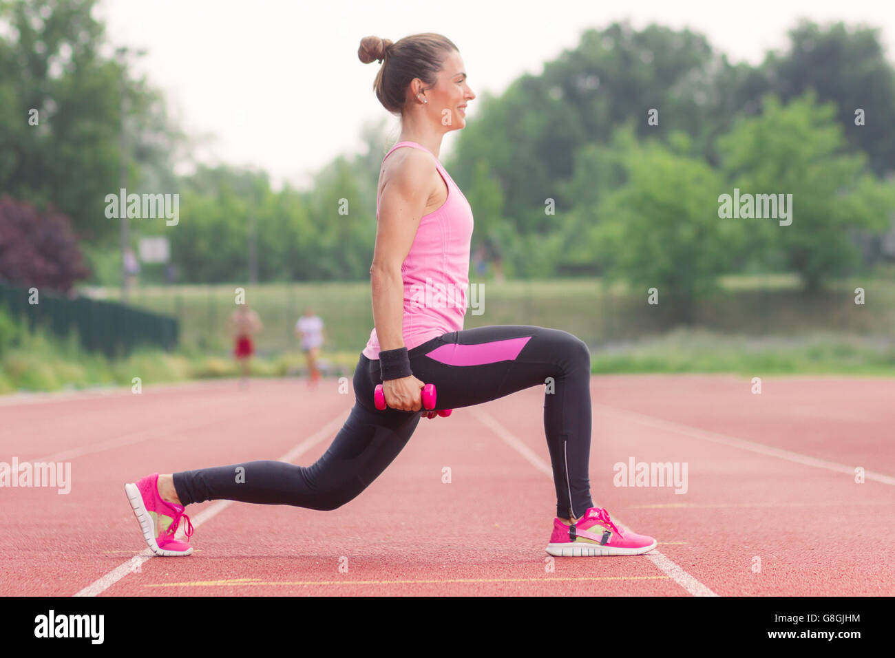 Seite Ansicht Mädchen hocken Gewichte im freien roten verfolgen Stockfoto