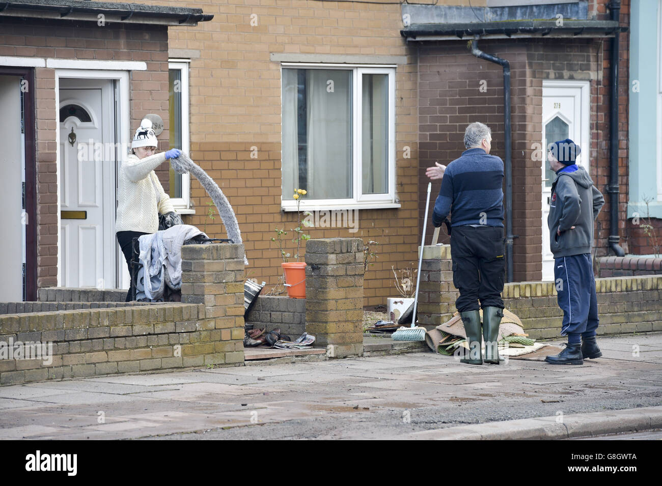 Die Menschen räumen ihre Häuser von Wasser beschädigt Eigentum als die Säuberung beginnt auf Warwick Road nach dem Hochwasser in Carlisle. Stockfoto