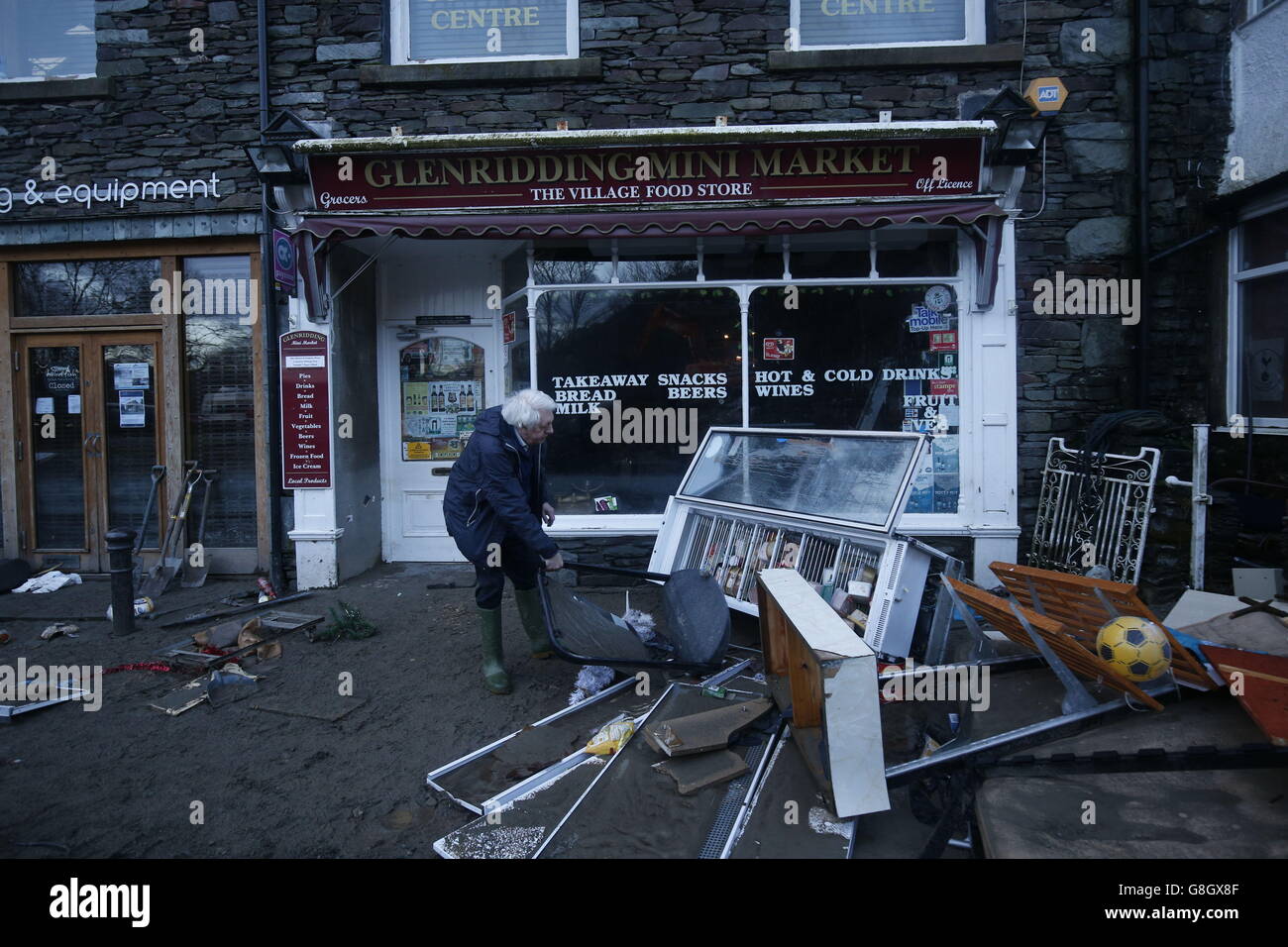 Allan John Brown untersucht die Schäden, die dem Glenridding Mini Market zugefügt wurden, nachdem der Fluss in der Stadt Cumbria nach anhaltenden Niederschlägen letzte Nacht wieder seine Ufer platzte. Stockfoto