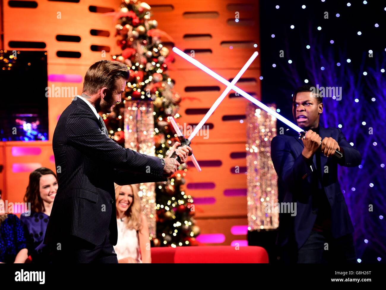 Daisy Ridley und Kylie Minogue lachen, als David Beckham und John Boyega während der Dreharbeiten zur Graham Norton Show in den London Studios im Süden Londons, die am Freitagabend auf BBC One ausgestrahlt werden, mit Lichtschäbeln spielen. Stockfoto
