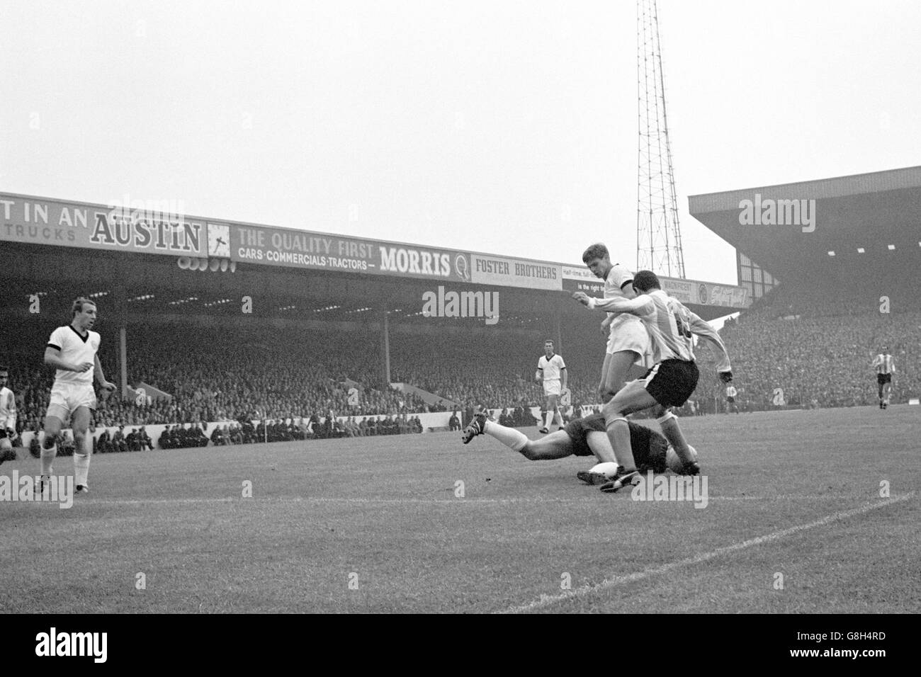 Westdeutschland Torwart Hans Tilkowski (am Boden) Tauchgänge zu Füßen von Argentiniens Luis Artime (r) zu Speichern als Teamkollege Wolfgang Weber (zweite r) hilft Stockfoto