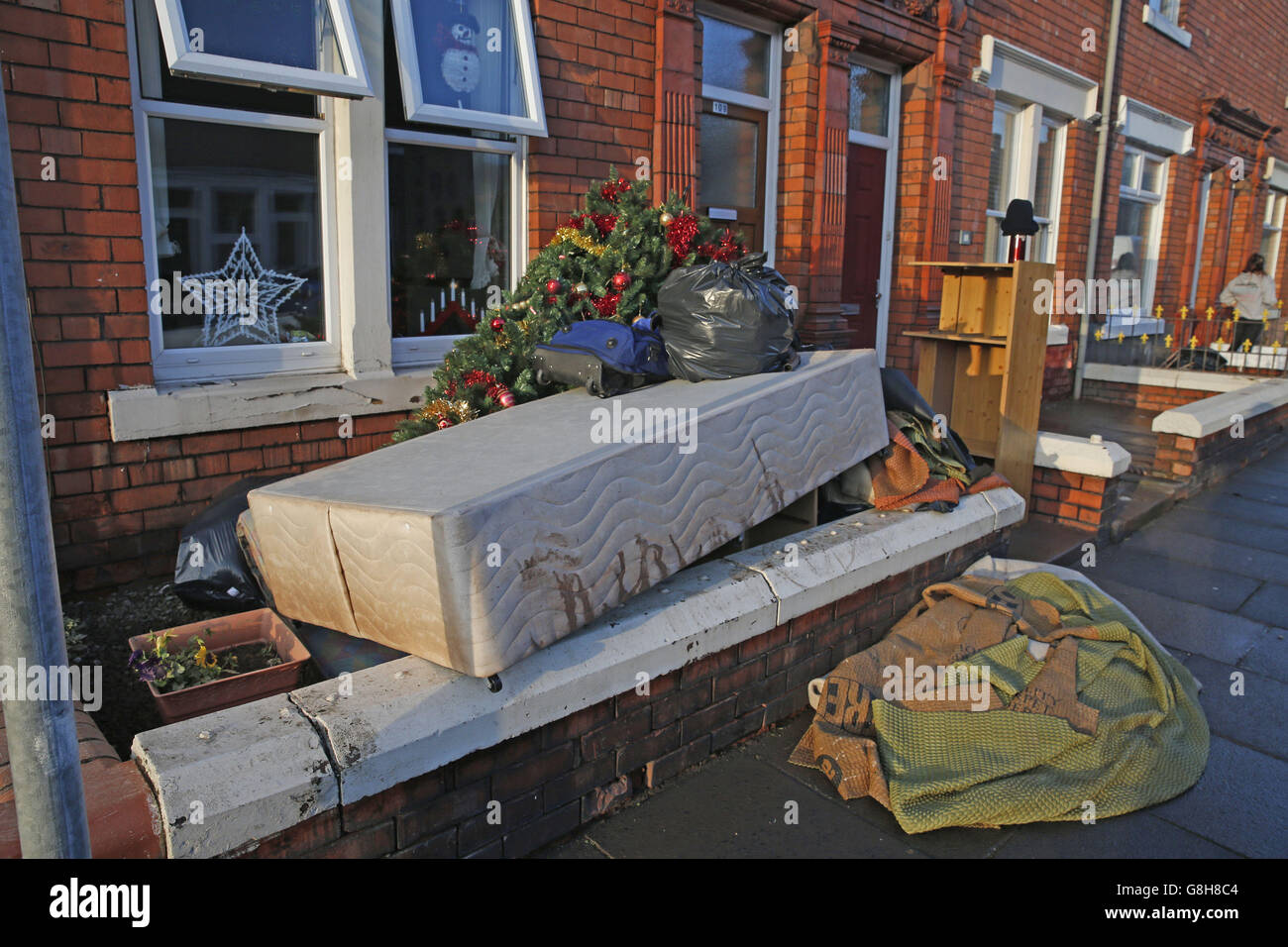 Die Habseligkeiten der Menschen, darunter ein Weihnachtsbaum, stapelten sich vor einem Haus in Carlisle, nachdem die Überschwemmung die Stadt getroffen hatte. Stockfoto