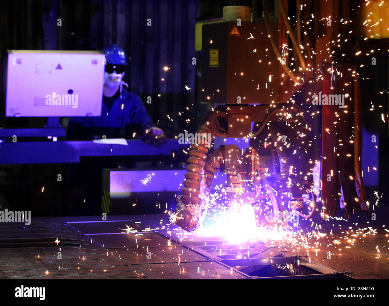 Ein Brenner verwendet einen Plasmaschneider, um Stahlplatten an Watson Towers in Coatbridge zu schneiden, um in die spezifischen Komponenten zu schneiden, die das Ende des Fachwerks auf der Forth Road Bridge fixieren. Stockfoto