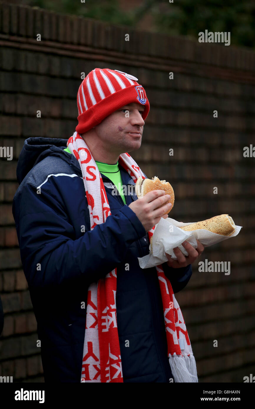 Ein Fan von Stoke City genießt einen Burger vor dem Spiel der Barclays Premier League im Upton Park, London. DRÜCKEN SIE VERBANDSFOTO. Bilddatum: Samstag, 12. Dezember 2015. Siehe PA Geschichte FUSSBALL West Ham. Das Foto sollte lauten: John Walton/PA Wire. Stockfoto