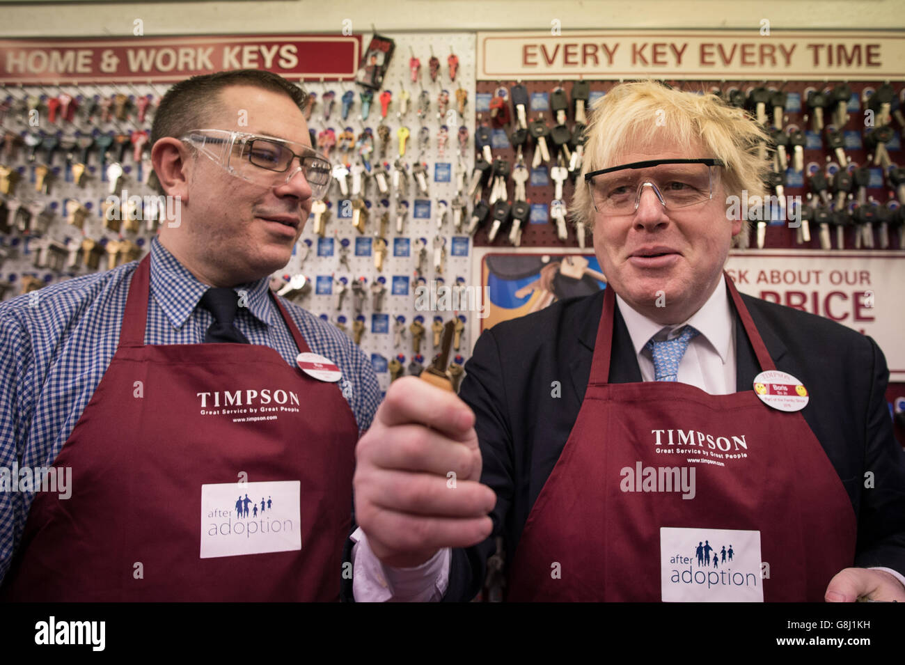 Der Bürgermeister von London, Boris Johnson, versucht sich bei Timpson in der City of London, Schlüssel zu schneiden und Schuhe auszubessern, wo er den Ex-Straftäter Russell Zecanovsky (links) traf, der von Timpson als Teil ihrer Politik zur Rekrutierung von Ex-Straftätern angestellt wurde. Stockfoto