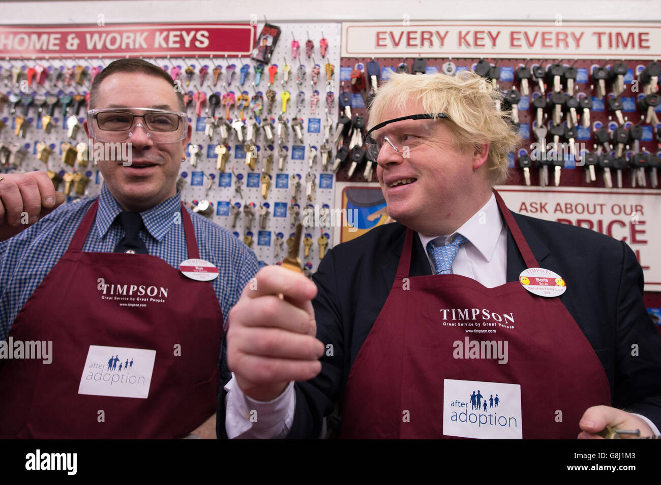 Der Bürgermeister von London, Boris Johnson, versucht sich bei Timpson in der City of London, Schlüssel zu schneiden und Schuhe auszubessern, wo er den Ex-Straftäter Russell Zecanovsky (links) traf, der von Timpson als Teil ihrer Politik zur Rekrutierung von Ex-Straftätern angestellt wurde. Stockfoto