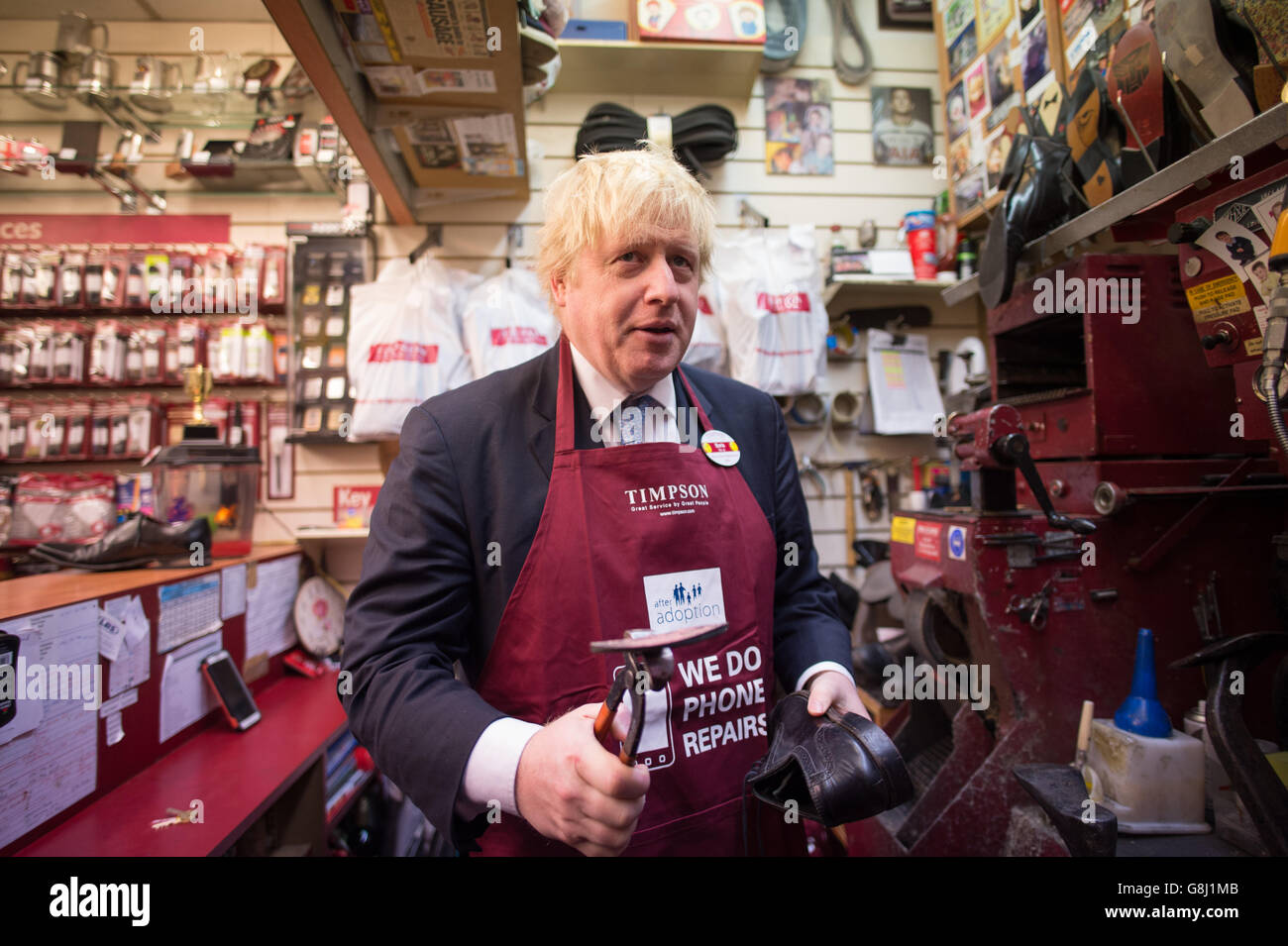 Der Bürgermeister von London, Boris Johnson, versucht bei Timpson in der City of London, Schlüssel zu schneiden und Schuhe auszubessern, wo er den Ex-Straftäter Russell Zecanovsky traf, der bei Timpson im Rahmen ihrer Politik zur Rekrutierung von Ex-Straftätern angestellt wurde. Stockfoto