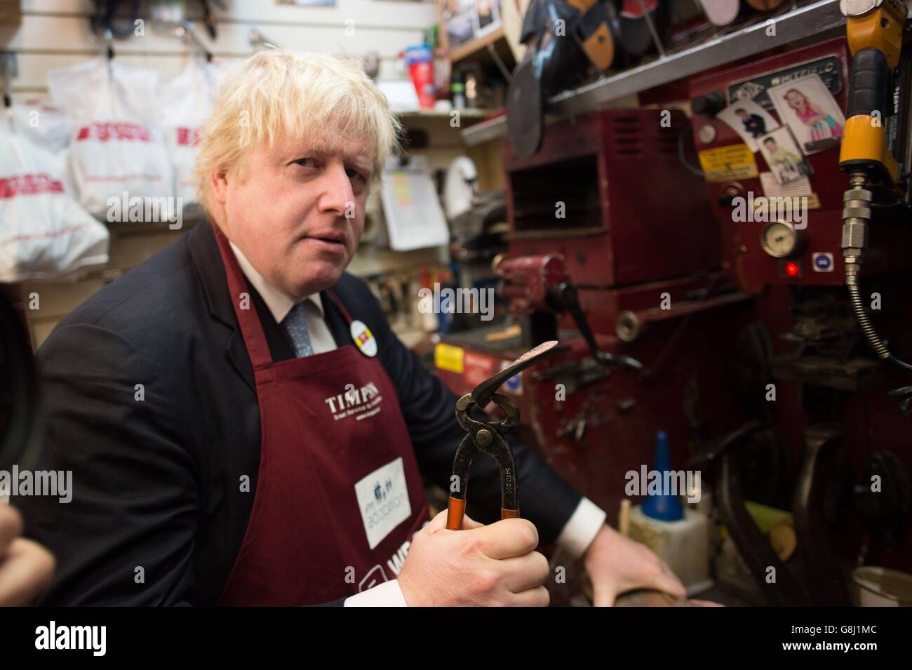 Der Bürgermeister von London, Boris Johnson, versucht bei Timpson in der City of London, Schlüssel zu schneiden und Schuhe auszubessern, wo er den Ex-Straftäter Russell Zecanovsky traf, der bei Timpson im Rahmen ihrer Politik zur Rekrutierung von Ex-Straftätern angestellt wurde. Stockfoto