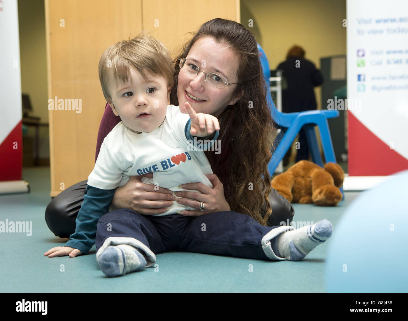 Sian Waugh und ihr 18 Monate alter Sohn Conan Waugh, dessen Leben durch eine Bluttransfusion gerettet wurde, als sie Menschen ermutigten, während einer Fotoanprobe im Glasgow Donor Center Blut zu spenden, ihre neue Jahresauflösung zu machen. Stockfoto