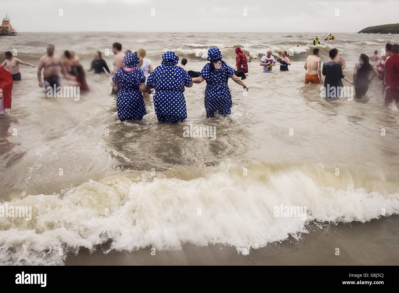 Menschen in ausgefallenen Kleidern im Meer auf Barry Island, in der Nähe von Cardiff in Wales, wo das jährliche Schwimmen am Neujahrstag stattfindet. Stockfoto
