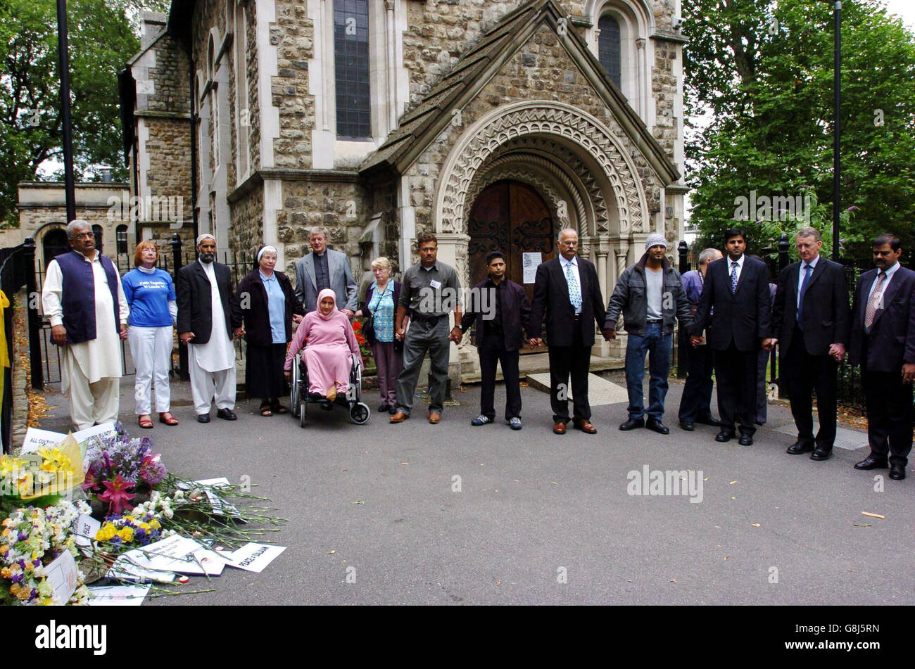 Eine Delegation aus der Beeston-Gemeinschaft in Leeds, Yorkshire, schließt sich während einer Schweigeminute bei einem Gedenkdienst in der St. Pancras Old Church nahe der Kings Cross Station in London an, um an die Opfer der Londoner Terroranschläge zu erinnern. Stockfoto