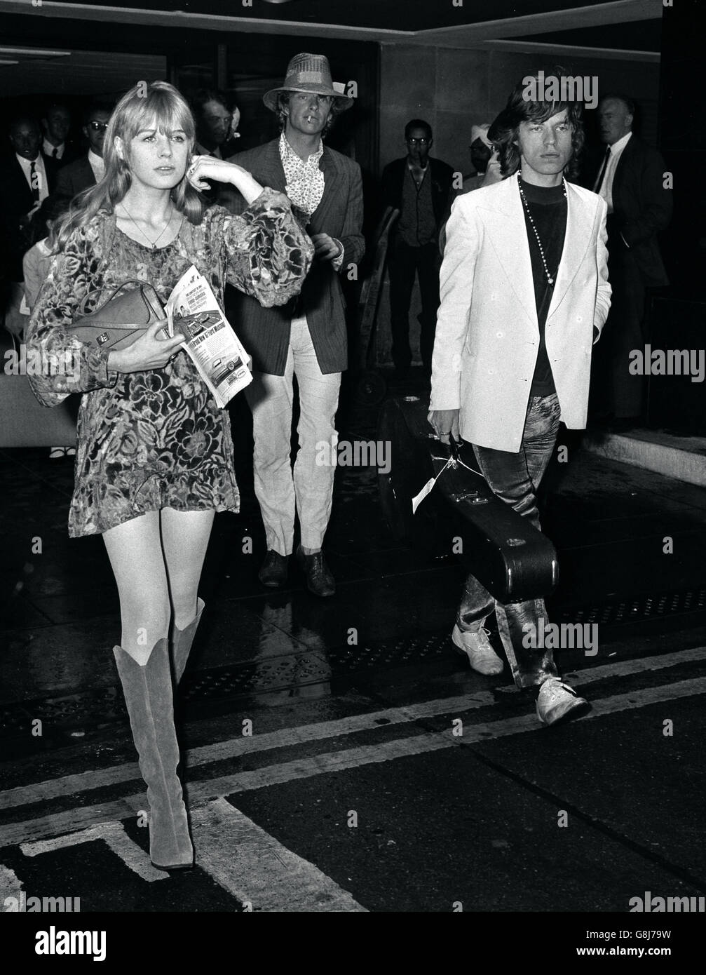 Mick Jagger, von den Rolling Stones, trägt eine Gitarrenhülle und seine Sängerin Marianne Faithfull. Stockfoto