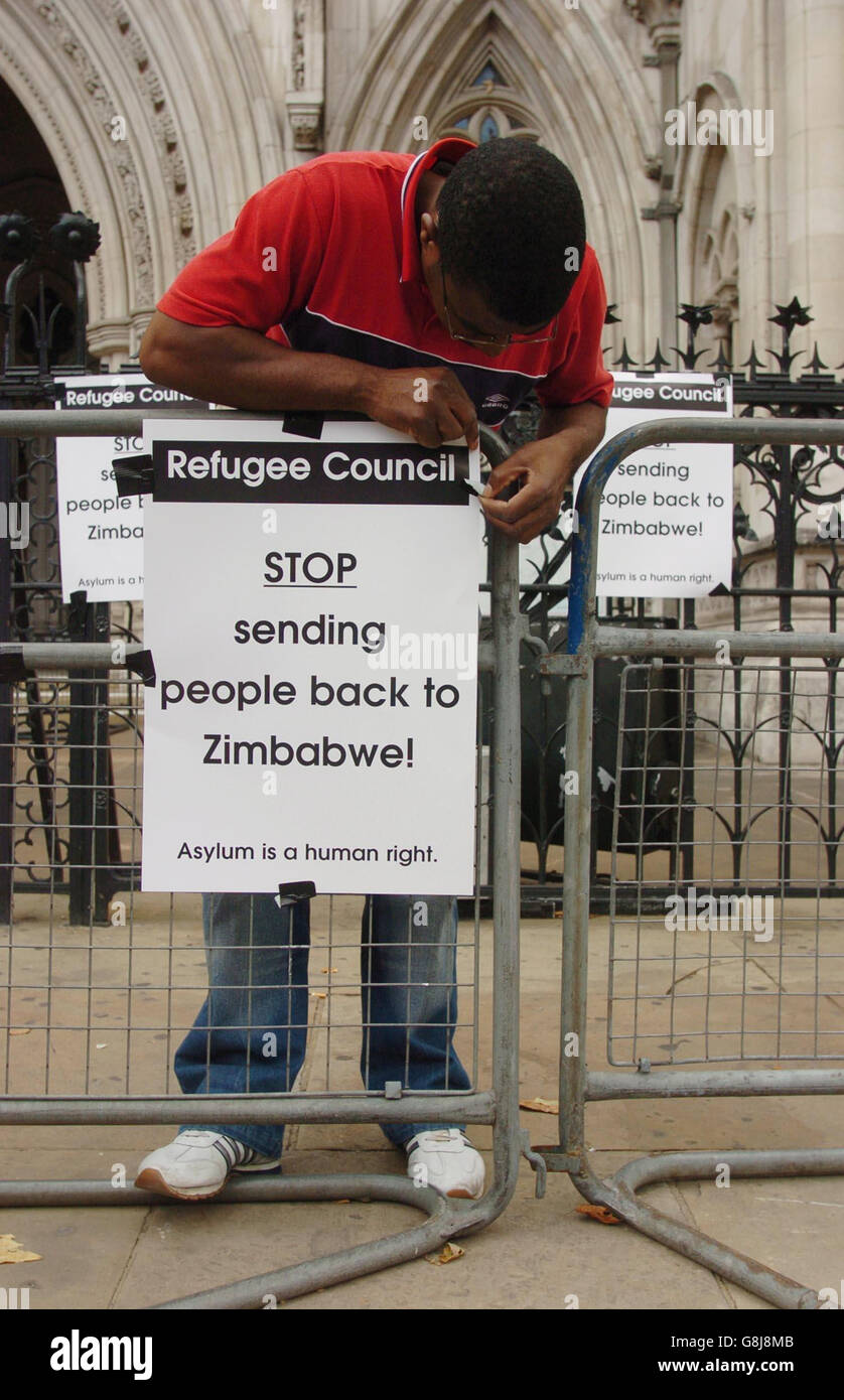 Washington Machokoto stellt Plakate mit dem Slogan "Stoppt die Rückführung von Menschen nach Simbabwe" als Teil einer "Solidaritätsvigil" auf, die vom United Network of Inhaftierten Simbabwes (UNDZ) vor den königlichen Gerichtshöfen organisiert wird. Der Flüchtlingsrat unterstützt die Mahnwache, da sich Aktivisten für die dauerhafte Verhinderung der Rückkehr simbabwischer Asylbewerber in ihr Land unter der Regierung von Robert Mugabe einsetzen. Stockfoto