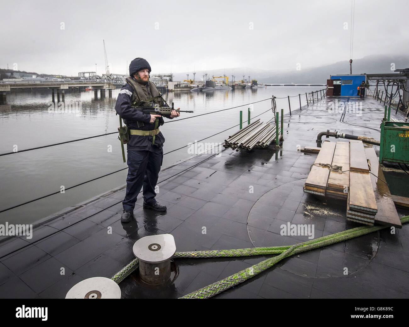 Ein Mitglied der bewaffneten Dienste auf dem Deck des Vanguard-Klasse-U-Bootes HMS Vigilant, eines der vier nuklearen Sprengköpfe tragenden U-Boote des Vereinigten Königreichs, am HM Naval Base Clyde, auch bekannt als Faslane, vor einem Besuch von Verteidigungsminister Michael Fallon. Stockfoto