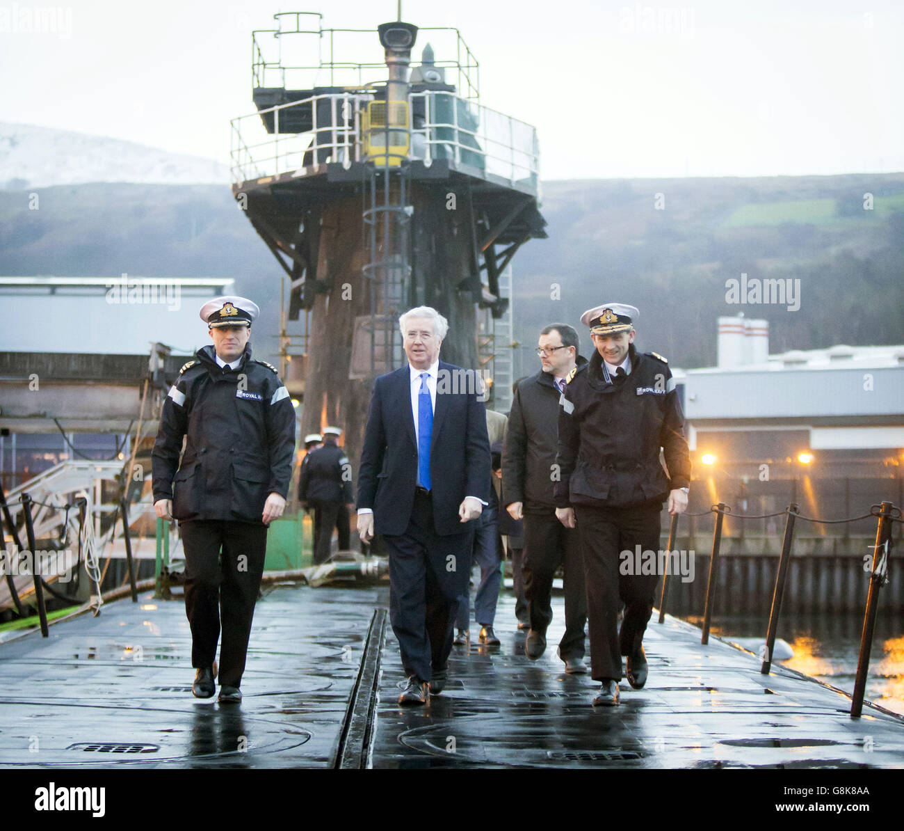 Verteidigungsminister Michael Fallon (Mitte) mit Daniel Martyn (links) Kommandant der HMS Vigilant und Konteradmiral der U-Boote und Assistant Chief of Naval Staff John Weale (rechts) bei einem Besuch des Vanguard-Klasse-U-Bootes HMS Vigilant, eines der vier nuklearen Kriegsheadträger-U-Boote des Vereinigten Königreichs, auf dem HM Naval Base Clyde, Auch bekannt als Faslane, in Schottland. Stockfoto