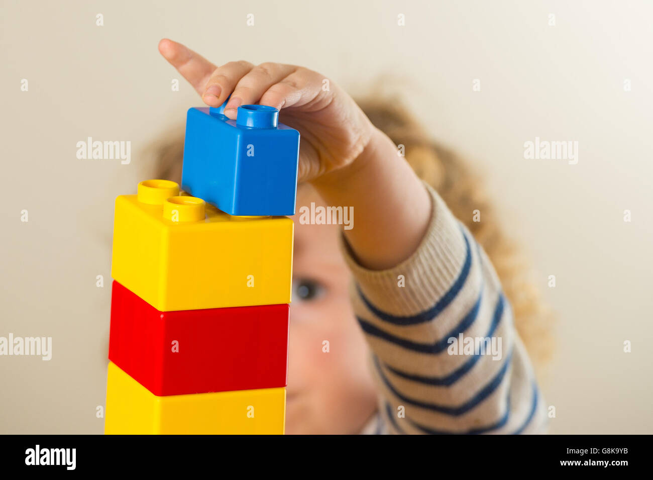Ein Kind im Vorschulalter spielt mit Plastikbausteinen. Stockfoto