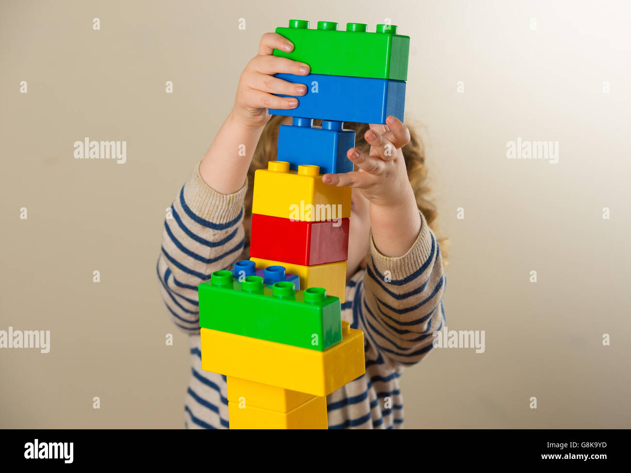 Ein Kind im Vorschulalter spielt mit Plastikbausteinen. Stockfoto
