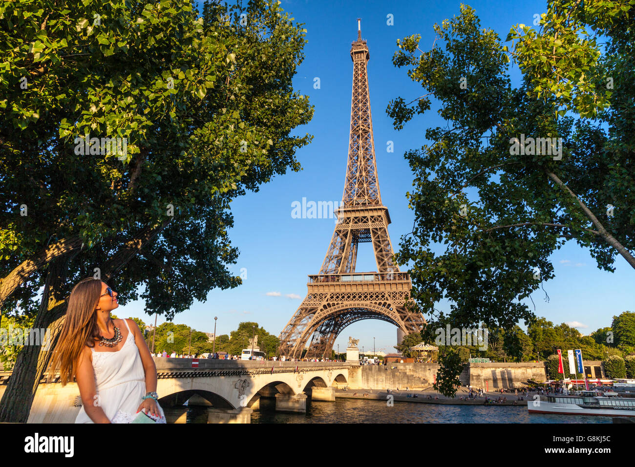 Schöne Mädchen posiert auf dem Seineufer Boulevards mit Eiffelturm (Tour Eiffel) im Hintergrund, Paris, Frankreich Stockfoto