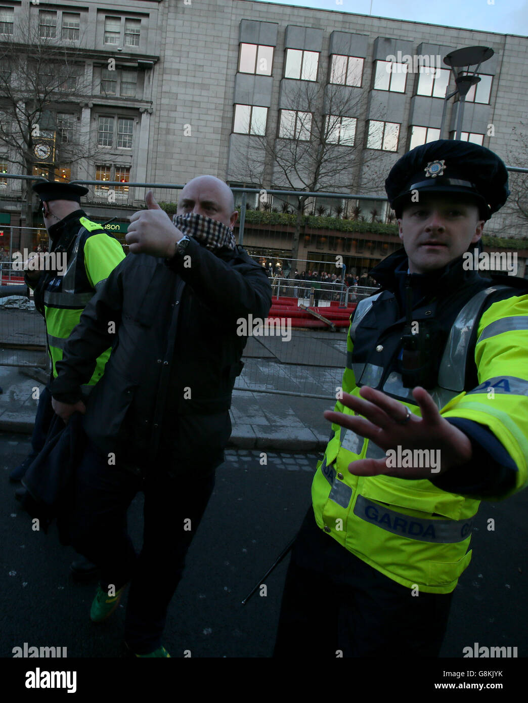 Gardai beschütze einen Mann in der O'Connell Street in Dublin während einer Gegendemonstration gegen den Start einer irischen Zweigstelle von Pegida, der rechtsextremen Bewegung aus Deutschland. Stockfoto